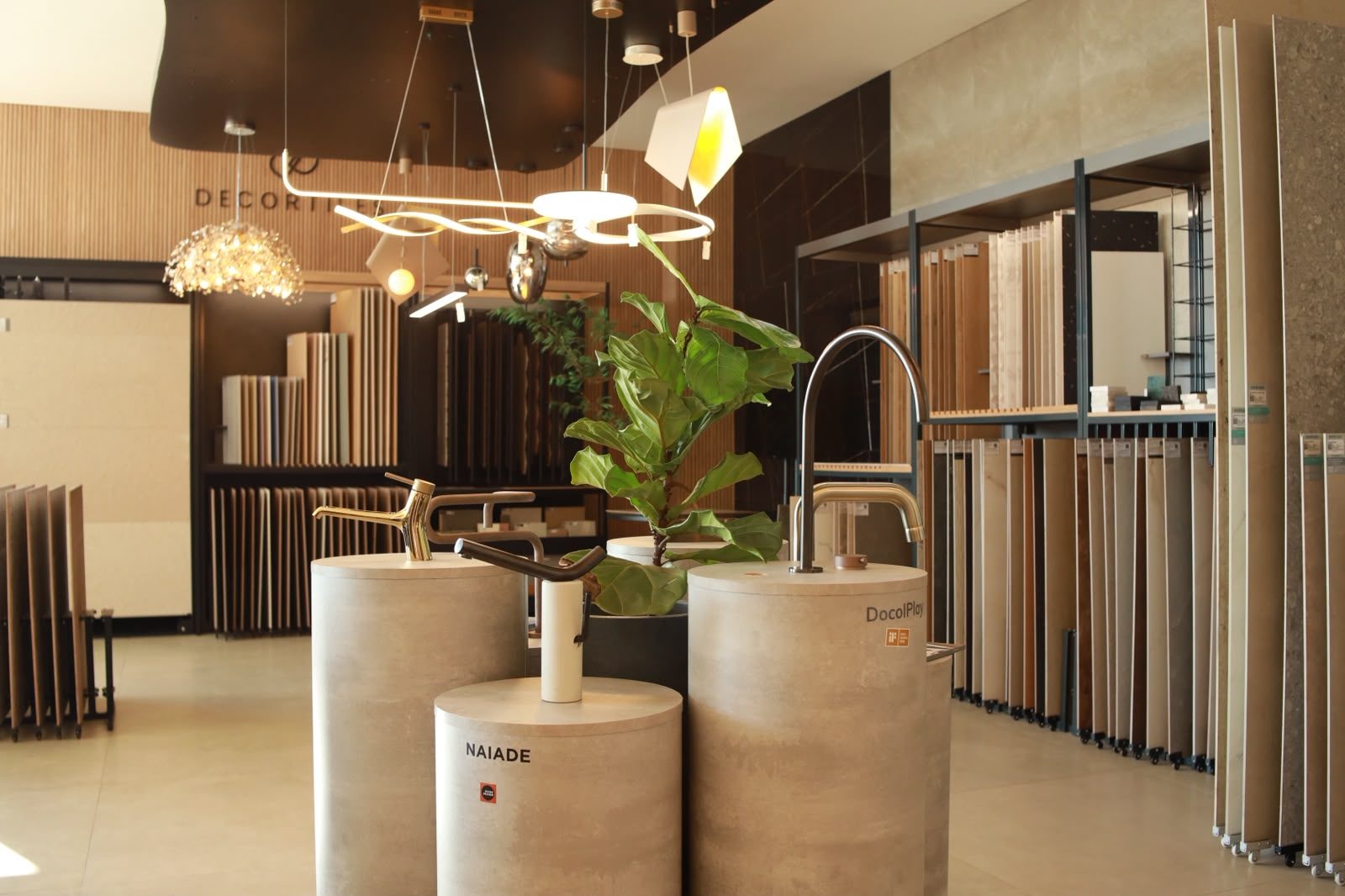 Interior do showroom da KMAC Acabamentos em Rio Verde, com expositores de porcelanato, metais e iluminação